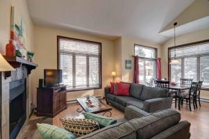 a living room with a couch and a television and a table at Excellent Townhome On Golf Course w/3 Bdrm 2 Bath in Mont-Tremblant