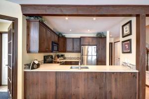 a kitchen with wooden cabinets and a kitchen island at Excellent Townhome On Golf Course w/3 Bdrm 2 Bath in Mont-Tremblant