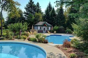 a swimming pool in a yard with a small house at Excellent Townhome On Golf Course w/3 Bdrm 2 Bath in Mont-Tremblant
