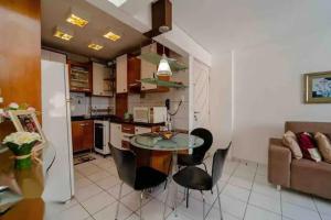 cocina y sala de estar con mesa y sillas en Apartamento aconchegante, en Natal