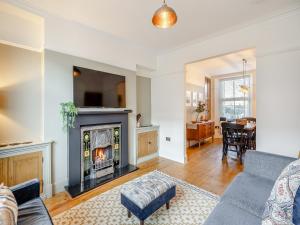 a living room with a couch and a fireplace at Raven House in Kendal