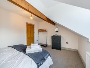 a bedroom with a bed and a dresser in a attic at Raven House in Kendal