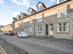 a street with cars parked in front of a brick building at Raven House in Kendal