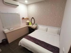 Un dormitorio con una gran cama blanca y una ventana en 儷池2房2-5人包棟 en Chishang