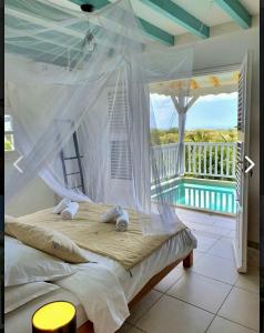 a bedroom with a bed with a hammock and a pool at Villa Lauréal in Grand-Bourg