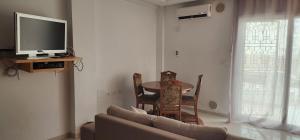 a living room with a couch and a table and a tv at Sousse apartment avec terrasse in Hammam Sousse