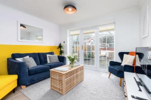 sala de estar con 2 sofás azules y TV en Very Close to Manchester Airport and Wythenshawe Hospital - Tailored for Monthly and Long Term Stays, en Sale