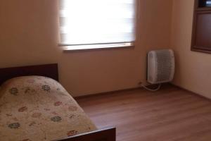 - une chambre avec un lit, une fenêtre et un ventilateur dans l'établissement Cheerful 4-bedroom home in Samtredia, Georgia, à Samtredia