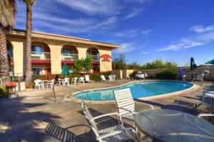a resort with a swimming pool and chairs and a hotel at Executive Inn Morgan Hill in Morgan Hill
