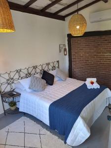 a bedroom with a large bed with a blue blanket at Pousada Santa Vila in Serra do Cipo