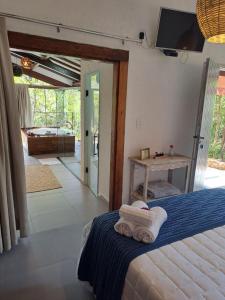1 dormitorio con 1 cama con toallas en Pousada Santa Vila, en Serra do Cipo