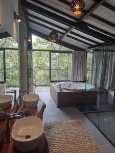 a large bathroom with two sinks and a tub at Pousada Santa Vila in Serra do Cipo