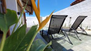two chairs sitting on a porch next to the beach at BG Sol e Mar - Chalé Mar in Barra Grande