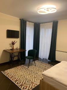 a hotel room with a table and a chair and a desk at pensiunea grecu in Lugoj
