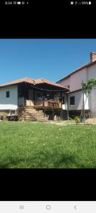 a house with a yard with a grass field at Събевата къща in Sinʼo Bŭrdo