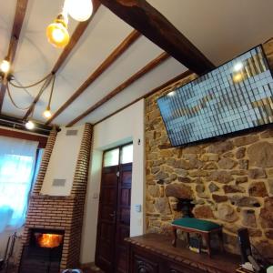 Una chimenea de piedra en una habitación con una pared de piedra. en TUUL ETXEA, Habitación en caserío a 8km de Bilbao, Baño compartido, en Galdakao