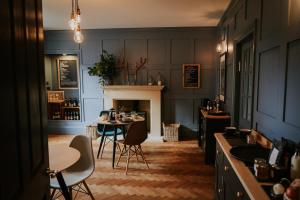 a room with two tables and chairs and a fireplace at Dacre House in Gilsland