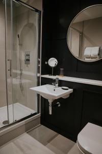 a bathroom with a sink and a shower and a mirror at Dacre House, Gilsland in Gilsland