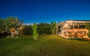 una casa con un jardín con una mesa de picnic en el patio en Romanza Luxury Villa, en Kalamaki