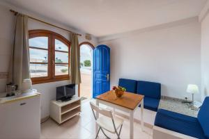 a living room with a table and a blue door at Precioso apartamento para nudistas y naturistas. in Charco del Palo