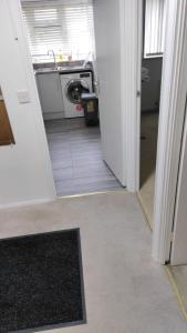 a hallway of a kitchen with a washing machine at A one spacious bedroom apartment in Welling