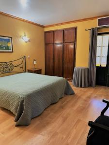 um quarto com uma cama e piso em madeira em Quinta do Chao D'Ordem em Vila Nova de Foz Côa