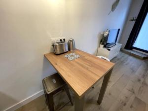 a wooden table with a toaster on top of it at ALP Chartres - Cosy studio au cœur de Chartres avec Parking in Chartres