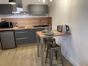 a kitchen with a table with two stools and a microwave at ALP Chartres - Cosy studio au cœur de Chartres avec Parking in Chartres