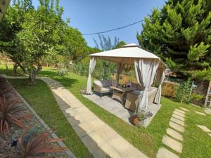 a gazebo with a couch and a table in a yard at Seaside house for 8 close to Olympia & the beach in Levendokhórion