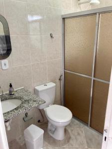 a bathroom with a toilet and a sink and a shower at Apartamento Frente para o mar in Ilha Comprida