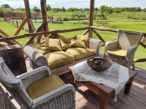un sofá en un porche con mesa y sillas en El Nopal - Alojamiento en San Pedro