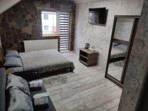a bedroom with two beds and a mirror at Margo in Yaremche
