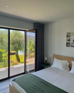 a bedroom with a bed and a large glass window at Casa D' Almeidas in Amares