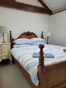 a bedroom with a wooden bed with blue and white pillows at The Long Barn in Skibbereen