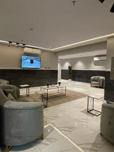 vestíbulo con sofás y TV de pantalla plana en sky hotel en Al Ula