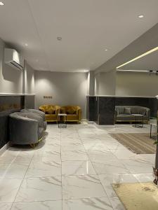 eine Lobby mit Sofas und Tischen und einem großen Fliesenboden in der Unterkunft sky hotel in Al-'Ula