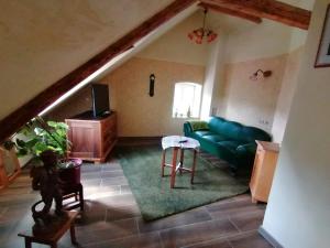 a living room with a green couch and a table at Ferienwohnungen Bistro Tebecks in Wadern