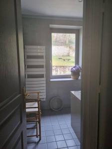 a bathroom with a window and a table and a chair at L'Ourse, Epinal,très bel appartement quartier Port in Épinal