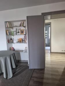 a room with a table and a book shelf at L'Ourse, Epinal,très bel appartement quartier Port in Épinal