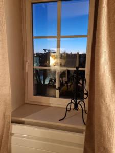 a window with a camera and a view of a city at L'Ourse, Epinal,très bel appartement quartier Port in Épinal
