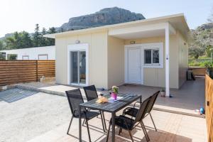 a patio with a table and chairs in front of a house at Stegna Holiday in Archangelos