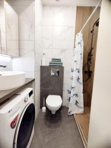 ein Badezimmer mit einem WC und einer Waschmaschine in der Unterkunft Stylish Central Station Apart & FREE PARKING in Vilnius