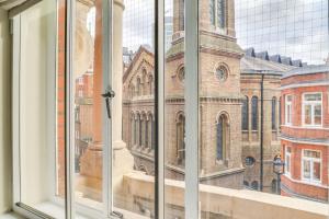 una ventana abierta con vistas a una iglesia en St James Westminster Apartment, en Londres