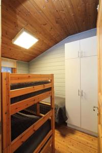 a room with a bunk bed and a ceiling with wooden ceilings at Lomariihi 1 in Muurame