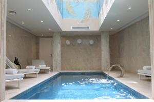 a swimming pool in a hotel room with a ceiling at Hotel Royal ASBU Tunis in Tunis