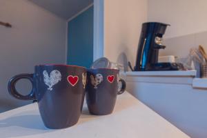 two coffee cups sitting on top of a counter at Le studio Bressan-cosy-clim in Coligny