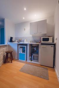 a small kitchen with a refrigerator and a microwave at Stud'ain in Coligny