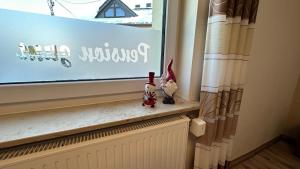 een vensterbank met twee kleine beeldjes erop bij Pension zum Winterberg in Elsterwerda