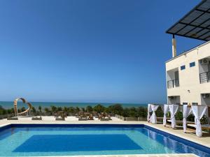 MoñitosHotel Bahia Rada的建筑物前的游泳池