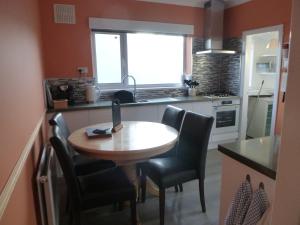 a kitchen with a table and chairs and a window at Daisychain Holidays in Bridlington